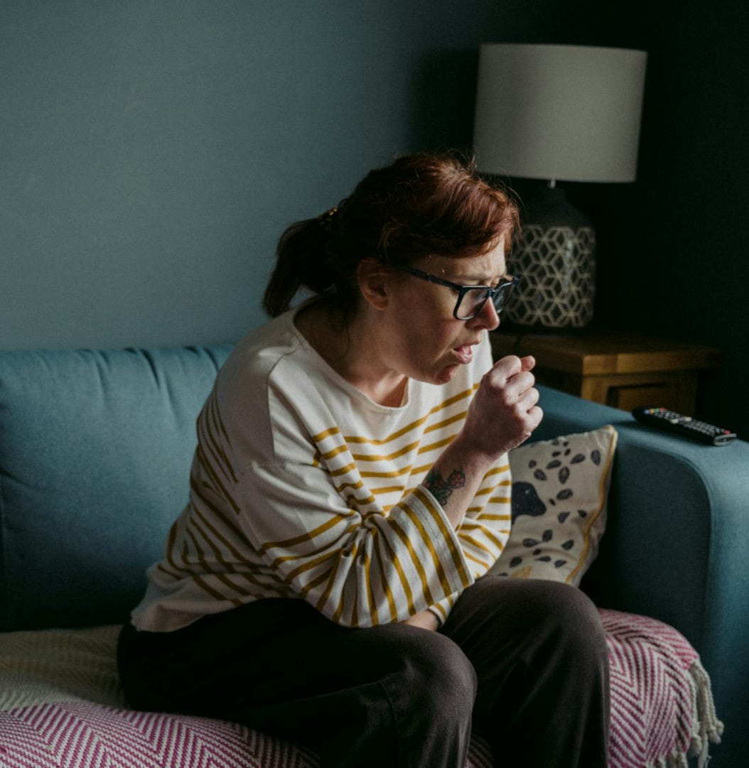 woman in white crew neck t-shirt sitting on gray sofa
