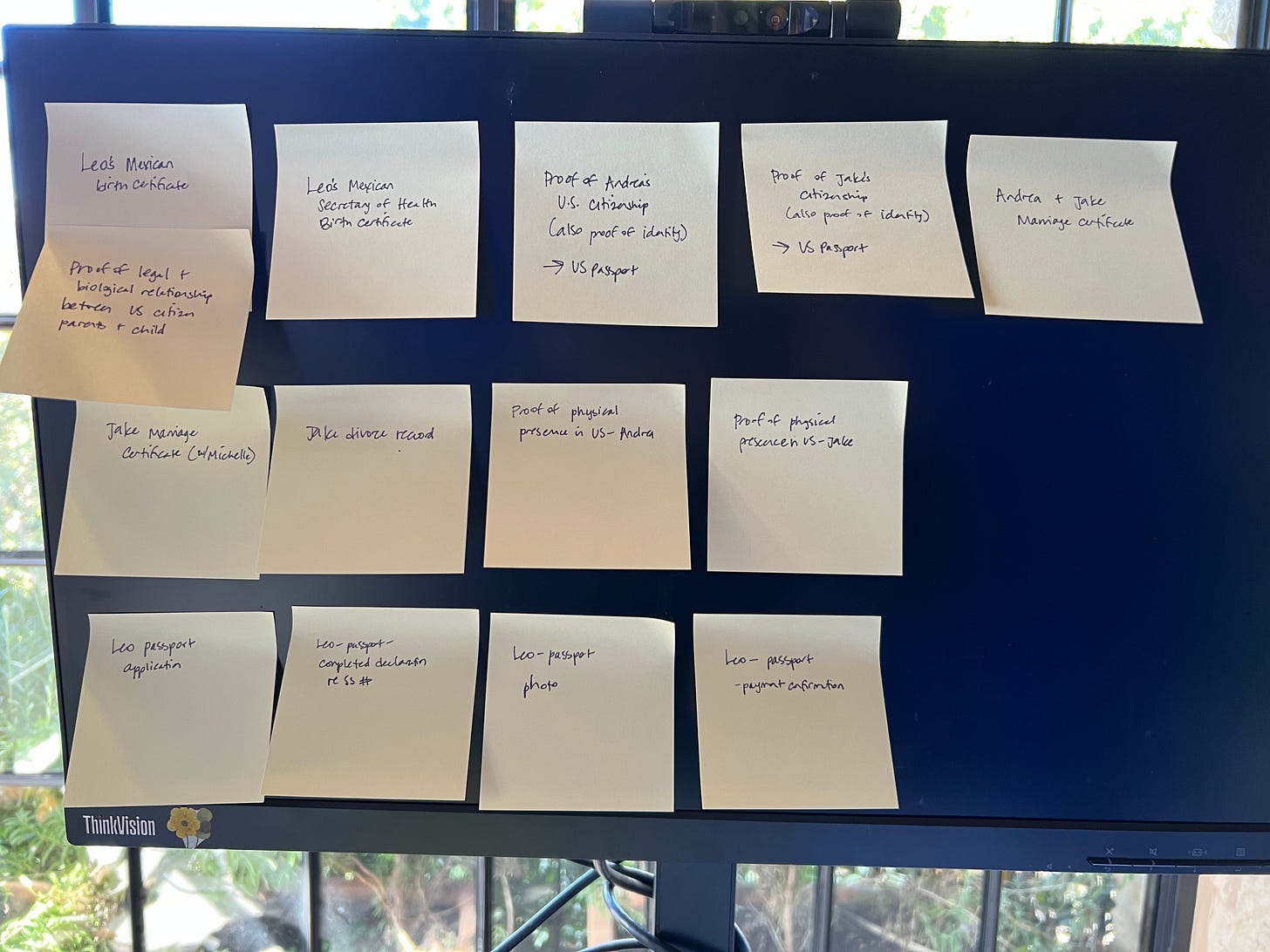 A computer monitor covered in sticky notes.