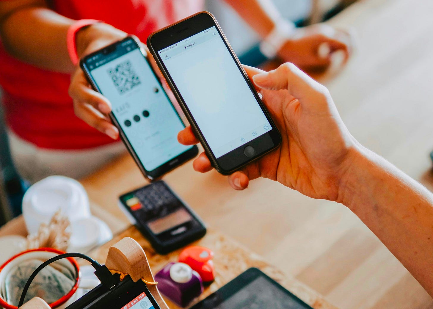 A person using their smartphone to scan a QR code displayed by a vendor, completing a digital payment transaction in a real-world setting, illustrating the use of cross-border cashless payments in Southeast Asia. A person using their smartphone to scan a QR code displayed by a vendor, completing a digital payment transaction in a real-world setting, illustrating the use of cross-border cashless payments in Southeast Asia.