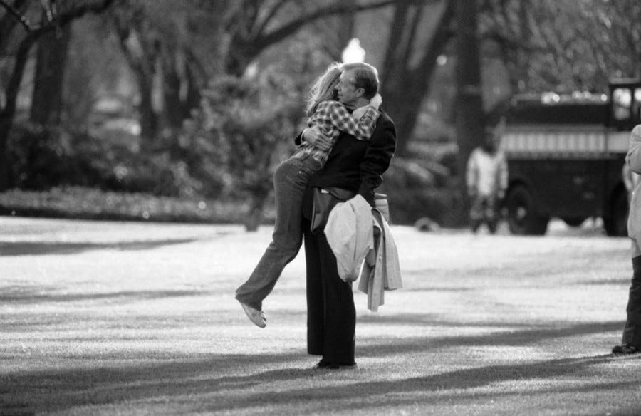 Jimmy Carter holds his daughter who has leapt into his arms.