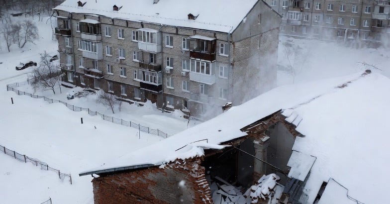 A snowy, desolate urban scene in a Ukrainian city, featuring damaged buildings in a wintry atmosphere.