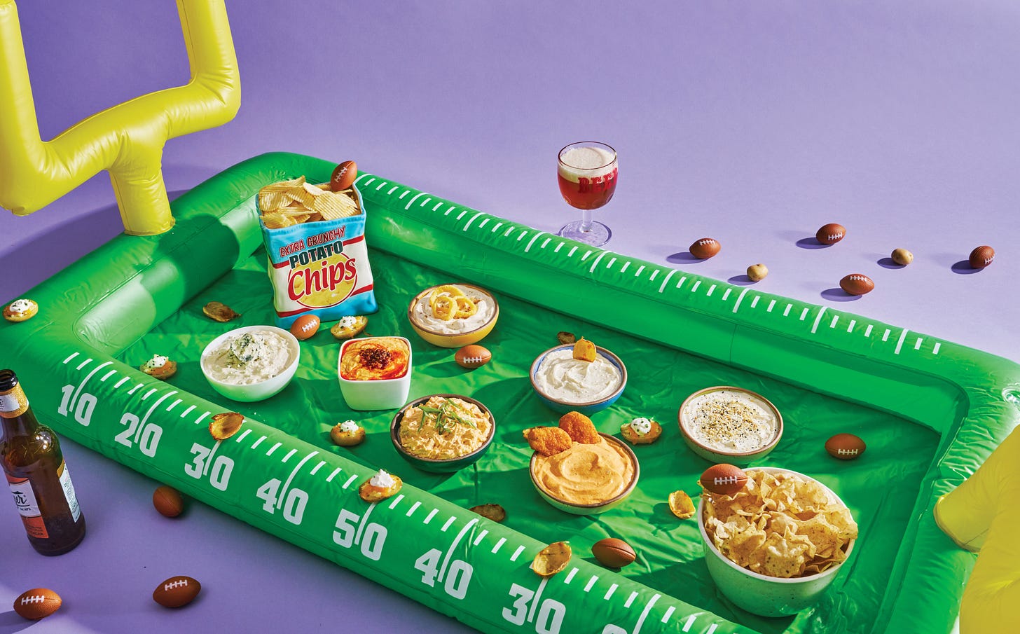 inflatable football field with assorted dips on top.