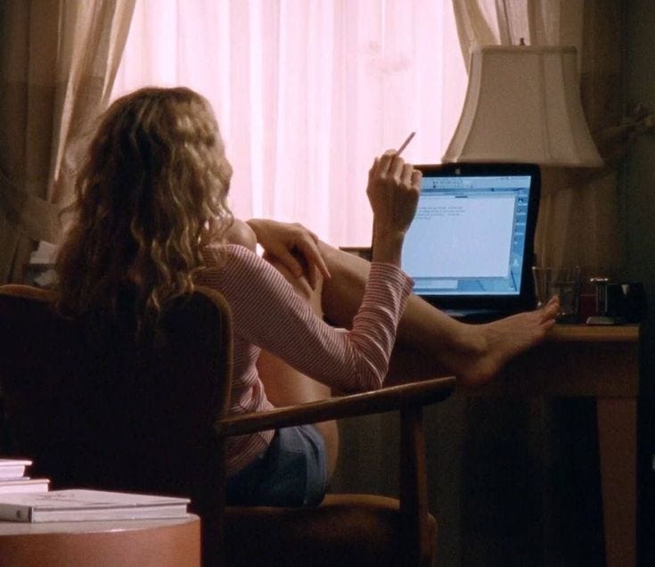 This may contain: a woman sitting in a chair writing on a computer screen