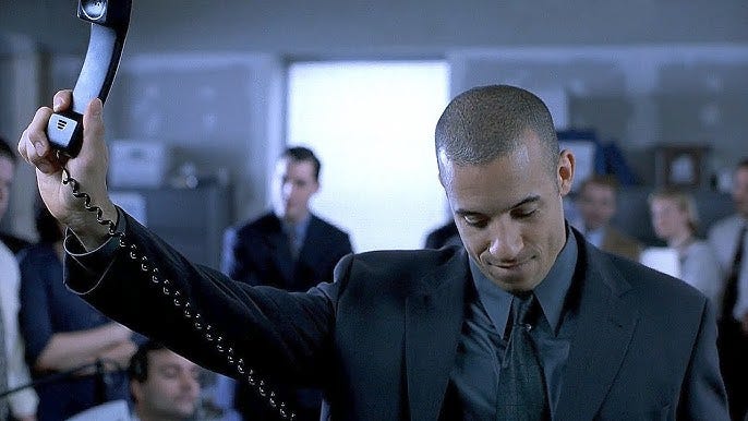 Salesman in Boiler Room holding up a phone after closing a deal, symbolizing aggressive sales culture. Salesman in Boiler Room holding up a phone after closing a deal, symbolizing aggressive sales culture.