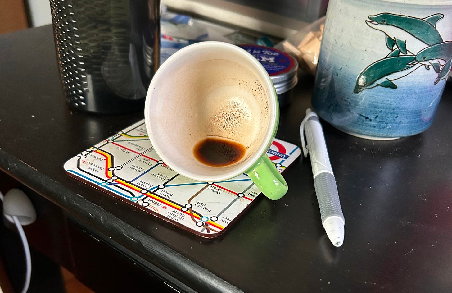 espresso cup on its side, on a coaster with an image of the london underground lines