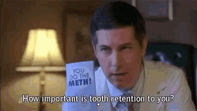 a man in a white suit is holding a piece of paper that says `` you do the meth '' . a man in a white suit is holding a piece of paper that says `` you do the meth '' .