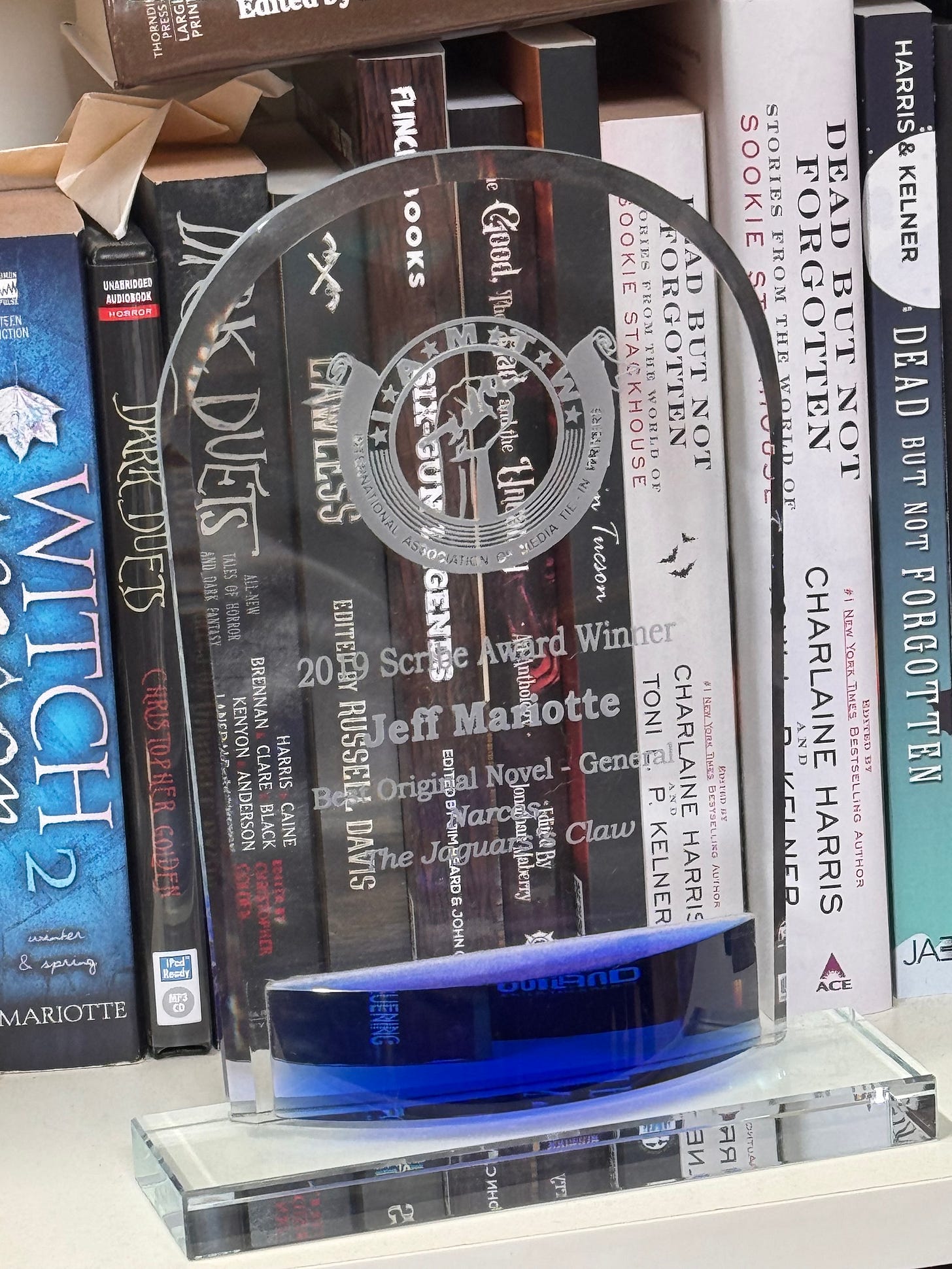 A glass trophy on a bookshelf