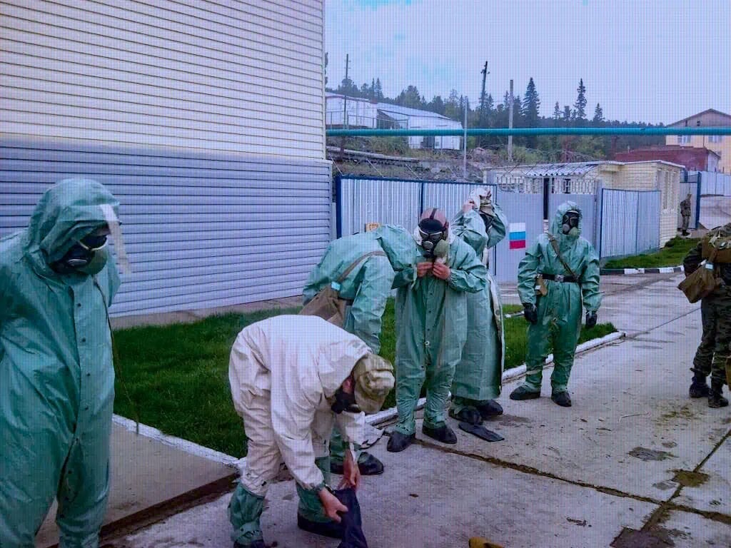An image showing soldiers in unit 20003 at the foot of Mount Kosvinsky putting on protective equipment for radioactive materials.