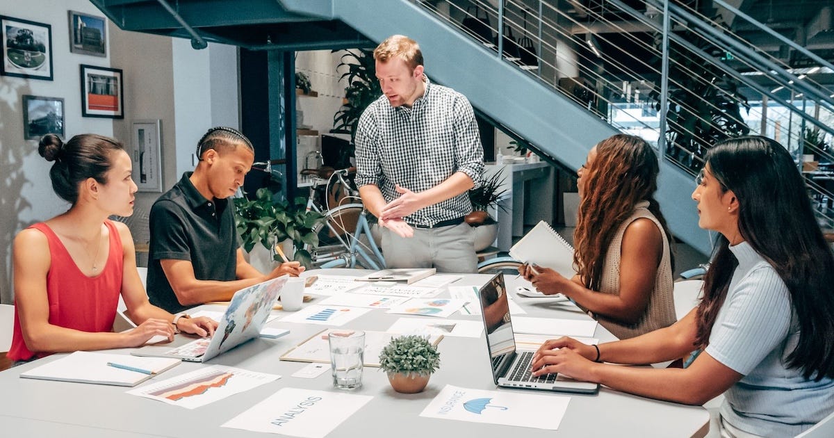 A team of business professionals having a strategic meeting in a modern office to discuss rewriting their brand story. A team of business professionals having a strategic meeting in a modern office to discuss rewriting their brand story.