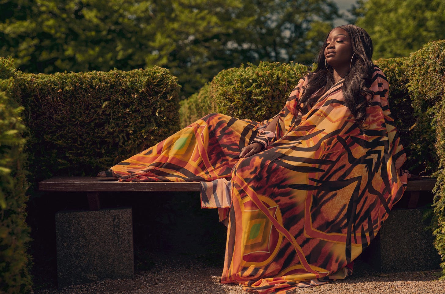 Lovette Jallow seated in sunlight, stillness after survival. Photo representing burnout, boundaries, and restoration after global community work.