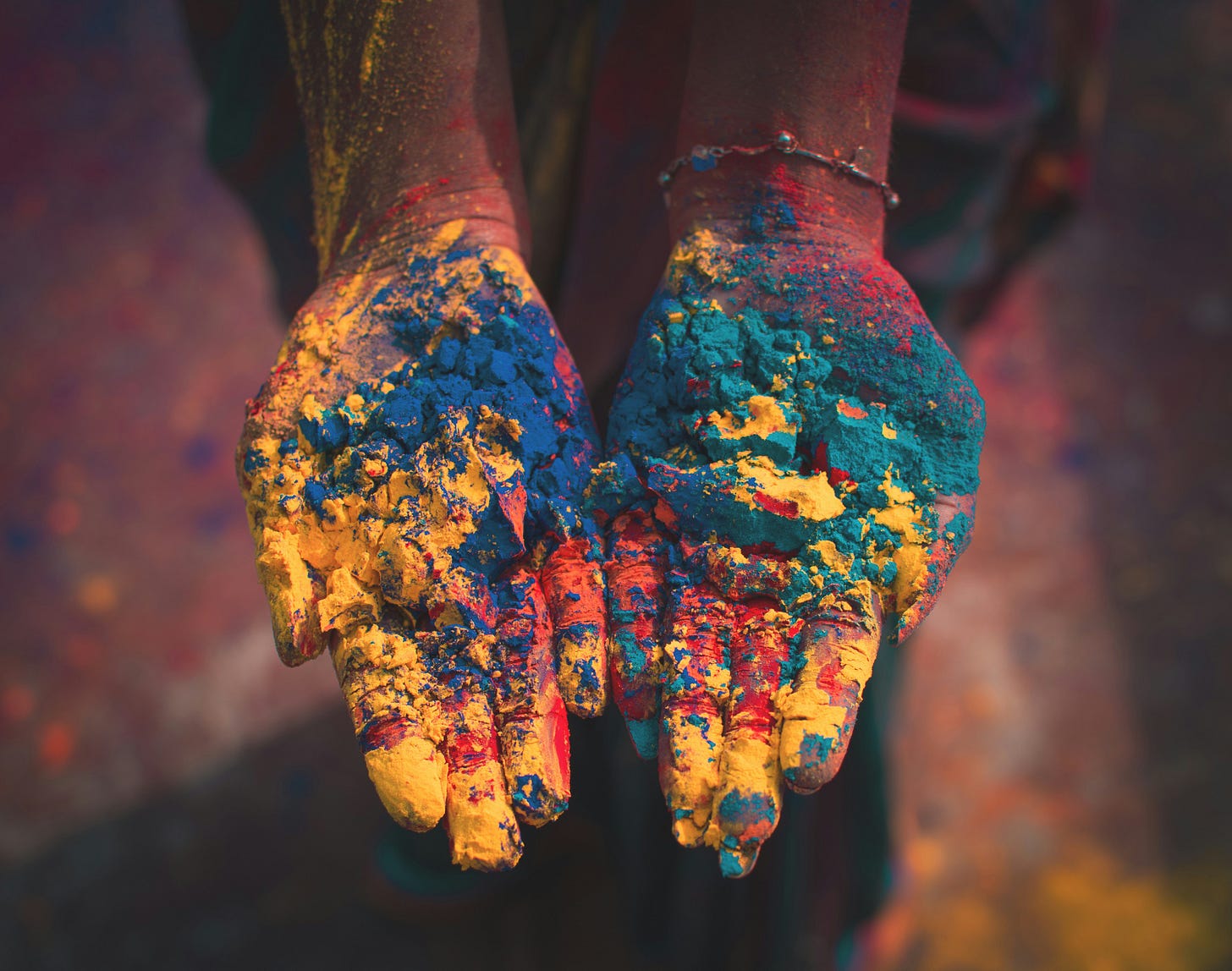 Hands holding multicolored powder