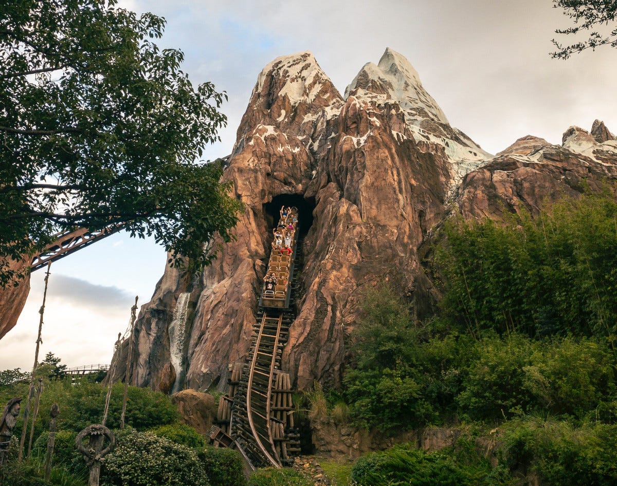 A roller coaster car emerges from a large fake mountain A roller coaster car emerges from a large fake mountain