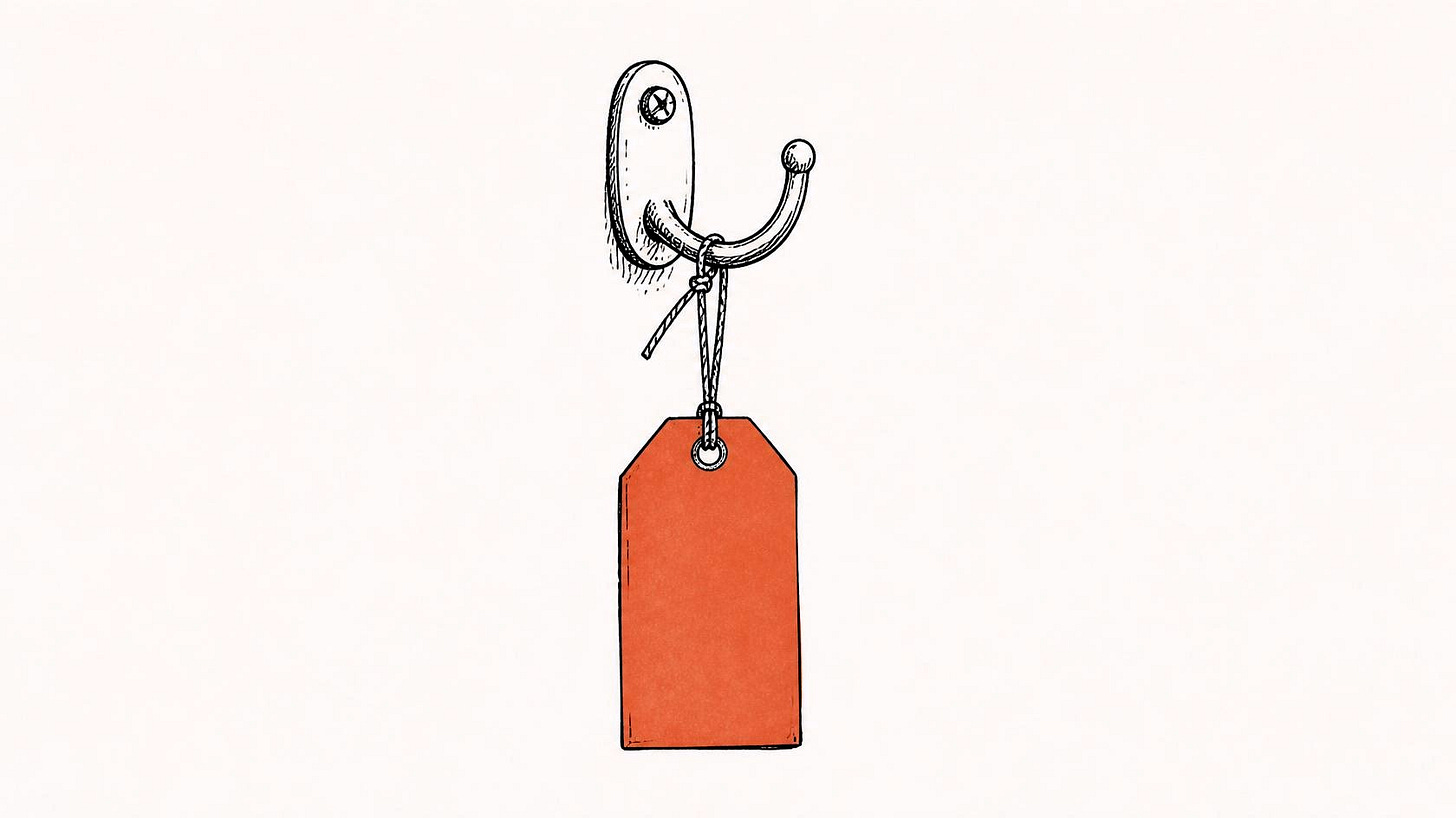 Blank orange-red tag tied to an empty wall hook with nothing attached