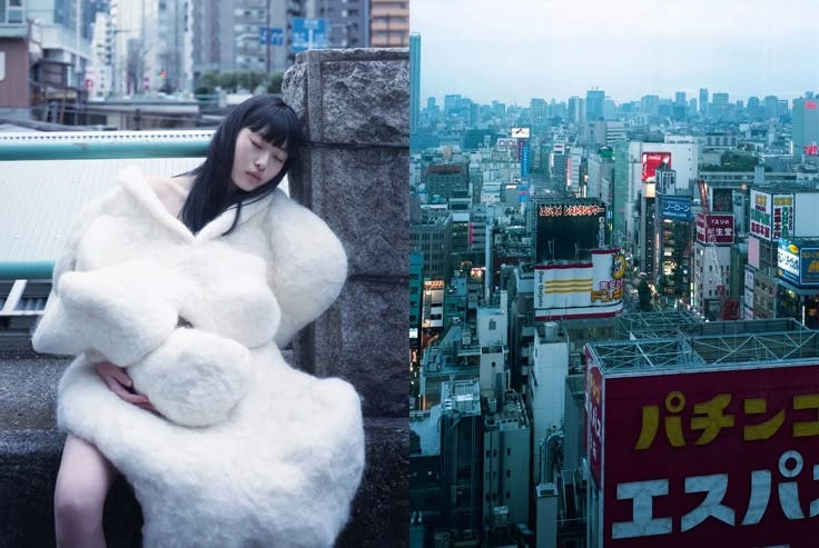 This may contain: a woman sitting on top of a building next to a large teddy bear in the city
