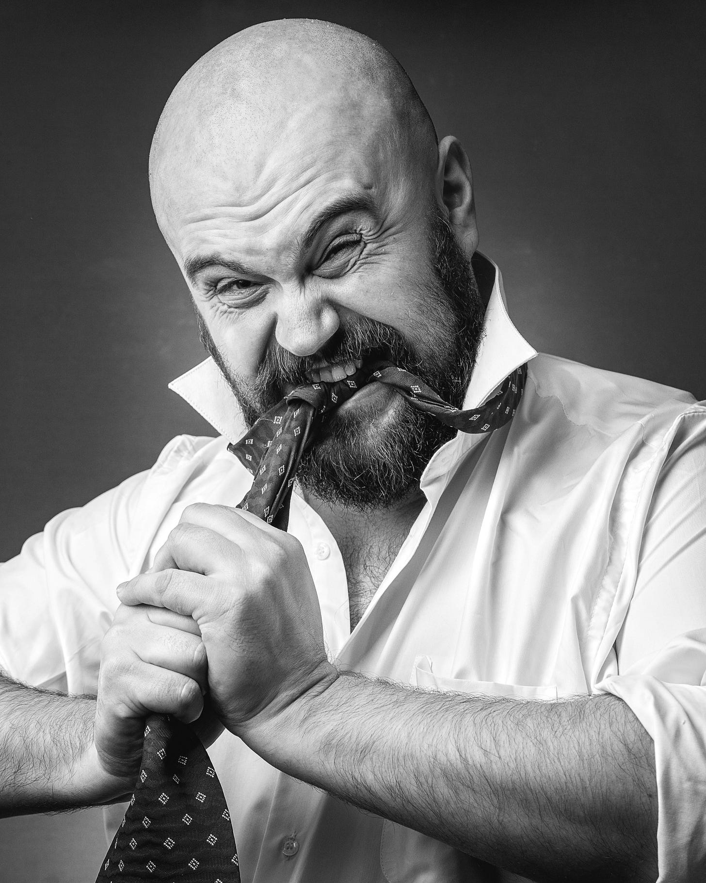 Stressed business executive pulling at his tie while struggling with workplace pressure and decision-making Stressed business executive pulling at his tie while struggling with workplace pressure and decision-making
