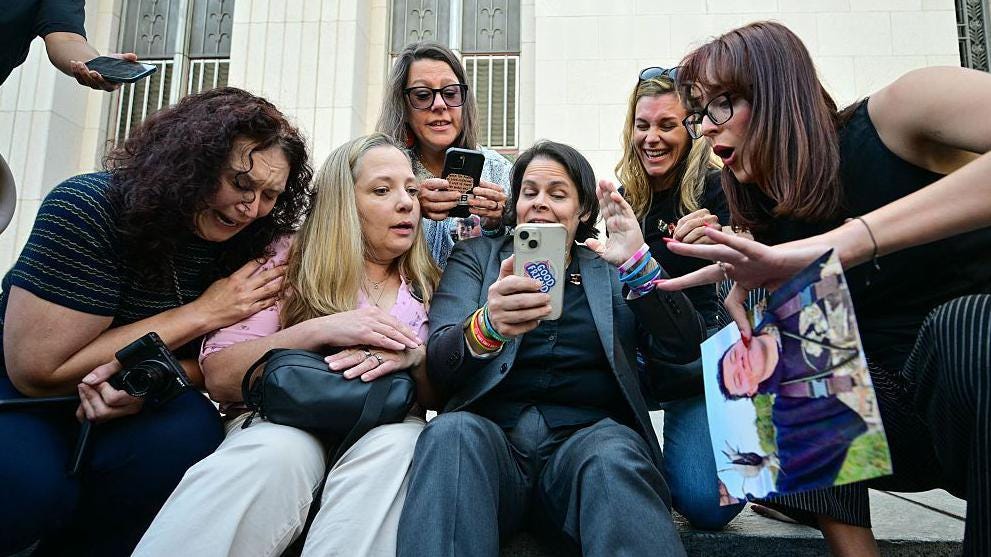 A group of women sit on steps in front of an Los Angeles courthouse and react with happiness and tears at verdict A group of women sit on steps in front of an Los Angeles courthouse and react with happiness and tears at verdict
