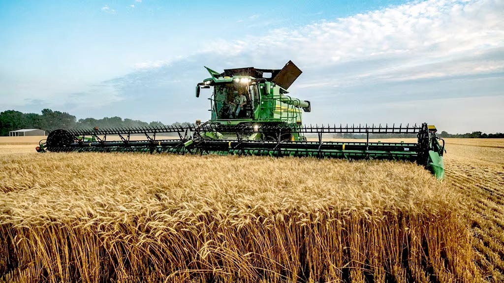 A John Deere combine at work in a wheat field.