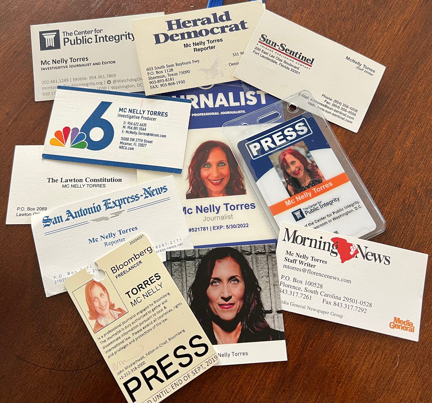 A collage of Mc Nelly Torres business cards and press passes from a number of newspapers and othe rmedia organizations she has worked for during her decades-long career. 
