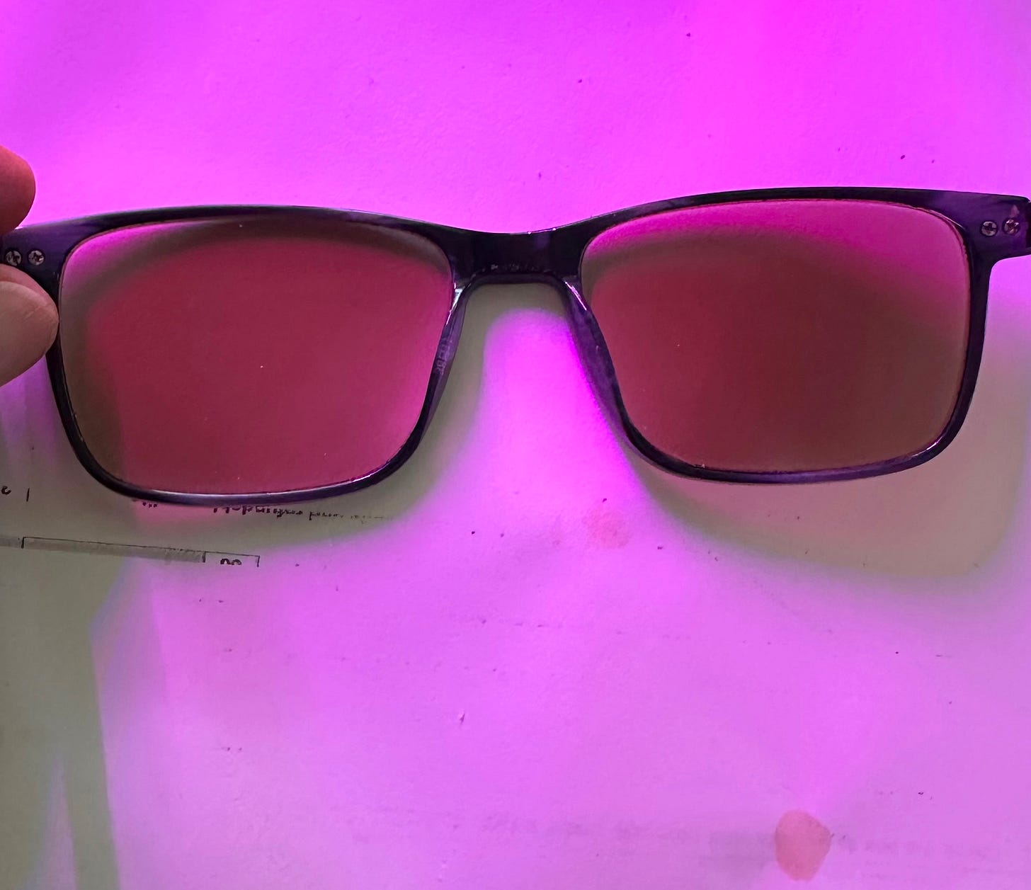 Darkened eyeglasses in front of a sheet of paper