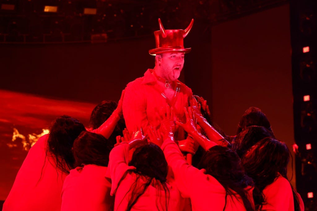 The non-binary singer rocked red high-heeled boots and leather pants, a red shirt and a matching collar and later wore a top hat with horns and completed the look with a cane. 