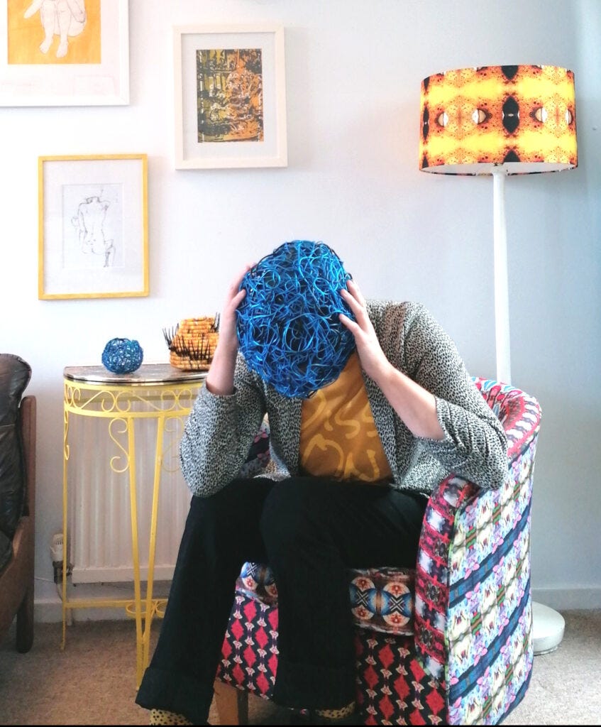 A seated white person grabs their head, which is a tangled skein of blue veins.