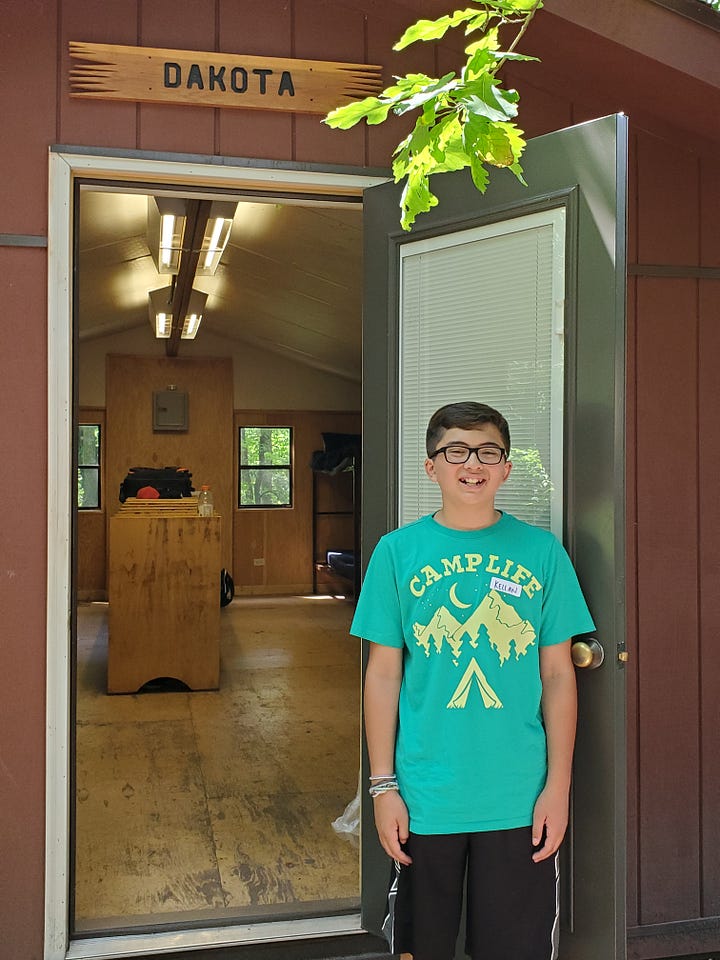 Posing with his cabin counselor and his riflery award