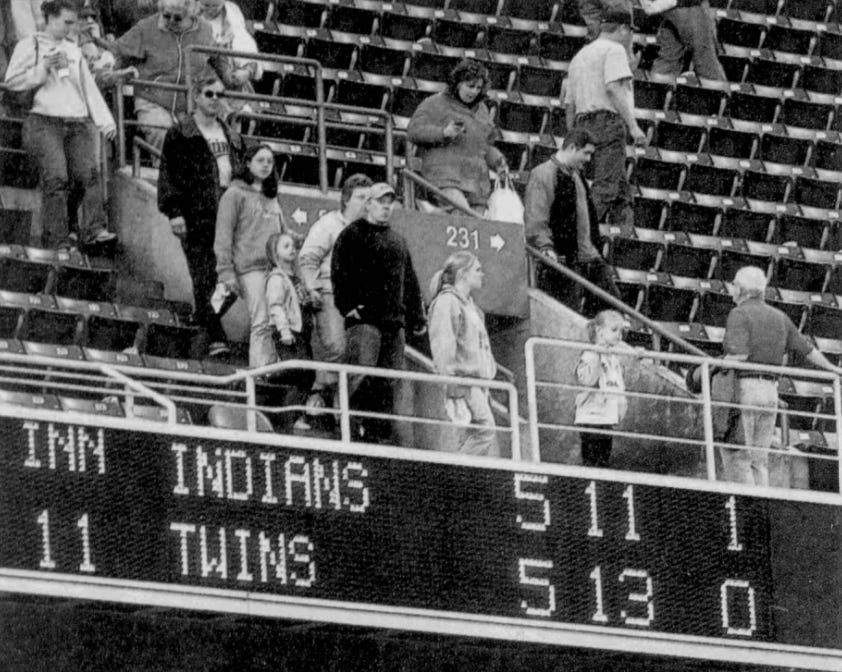 Fans leave the suspended game at the Metrodome above a scoreboard showing the tie score. Fans leave the suspended game at the Metrodome above a scoreboard showing the tie score.