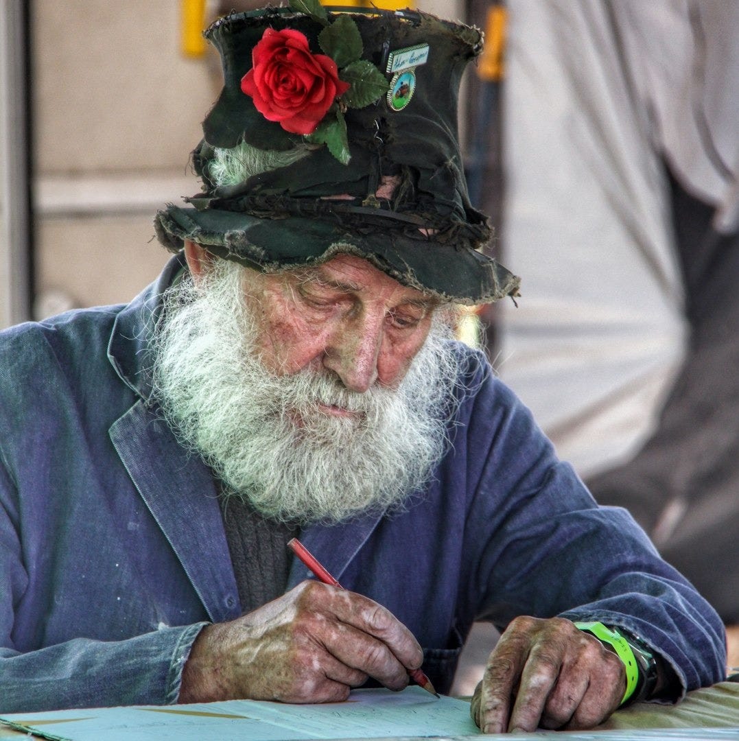 shallow focus photo of man writing on printing paper shallow focus photo of man writing on printing paper