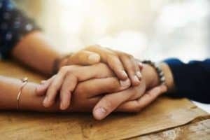two people holding hands in a supportive way