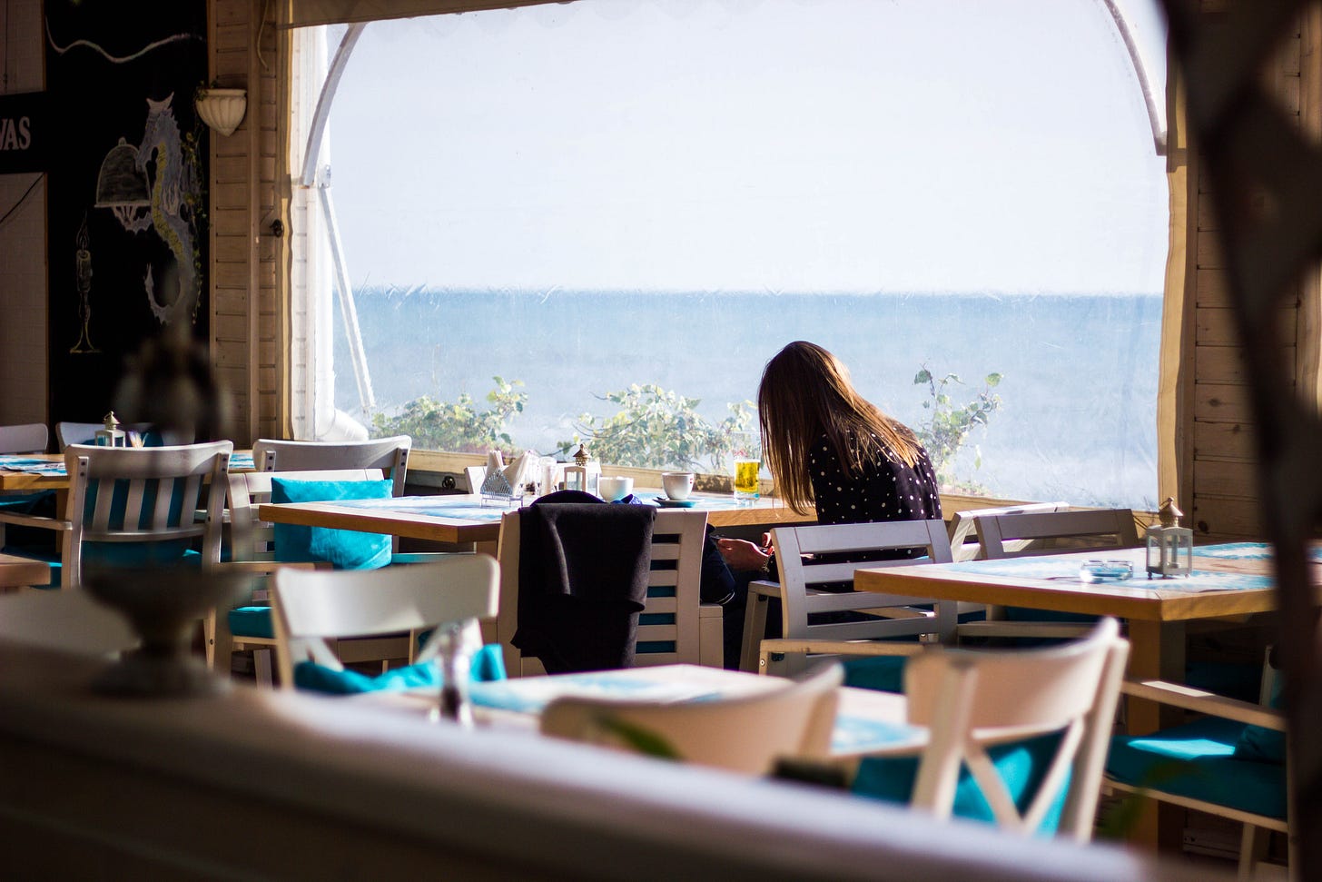 Woman Sitting on Chair With View of Sea Woman Sitting on Chair With View of Sea