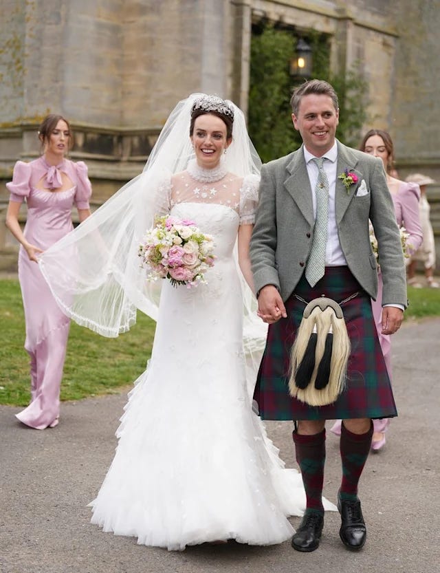 Bride carrying flowers with husband in a kilt and sporren