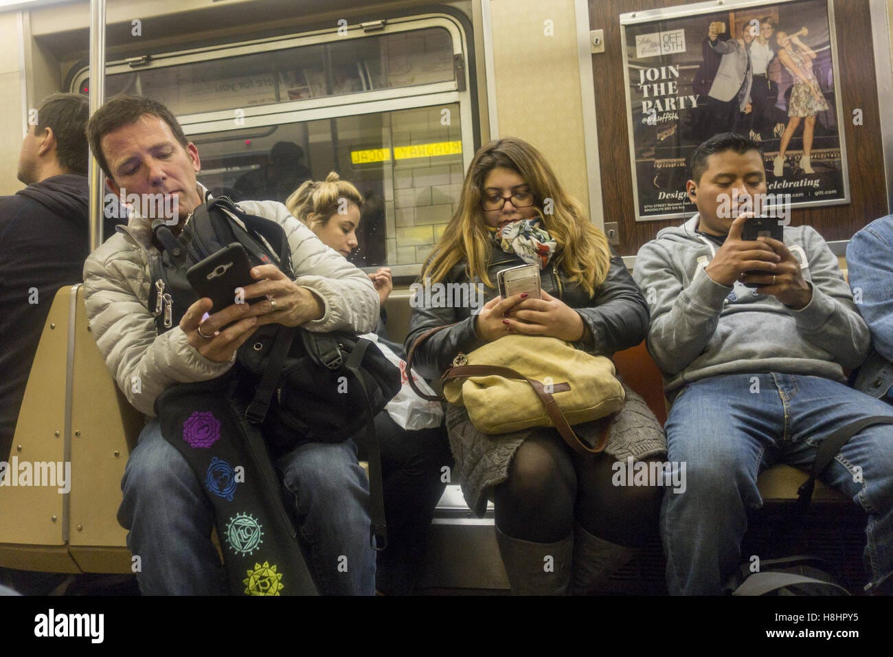Subway riders use their cell phones on their way home from work in the  evening rush hour in Brooklyn, NY Stock Photo - Alamy