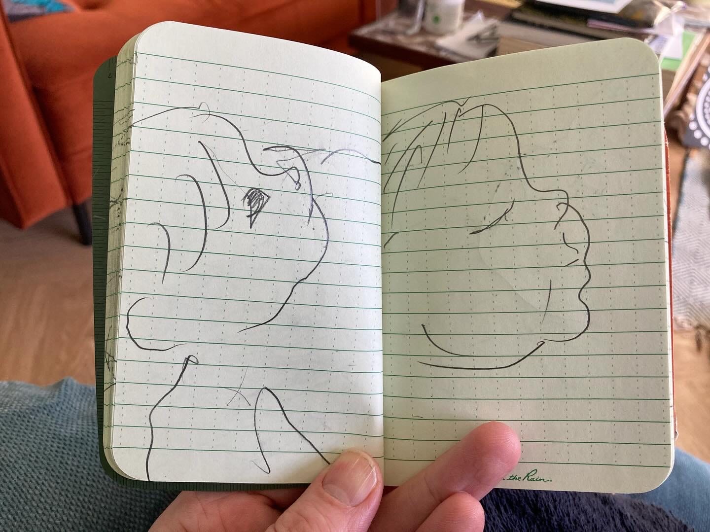 Two pencil drawings of a baby in a lined notebook.