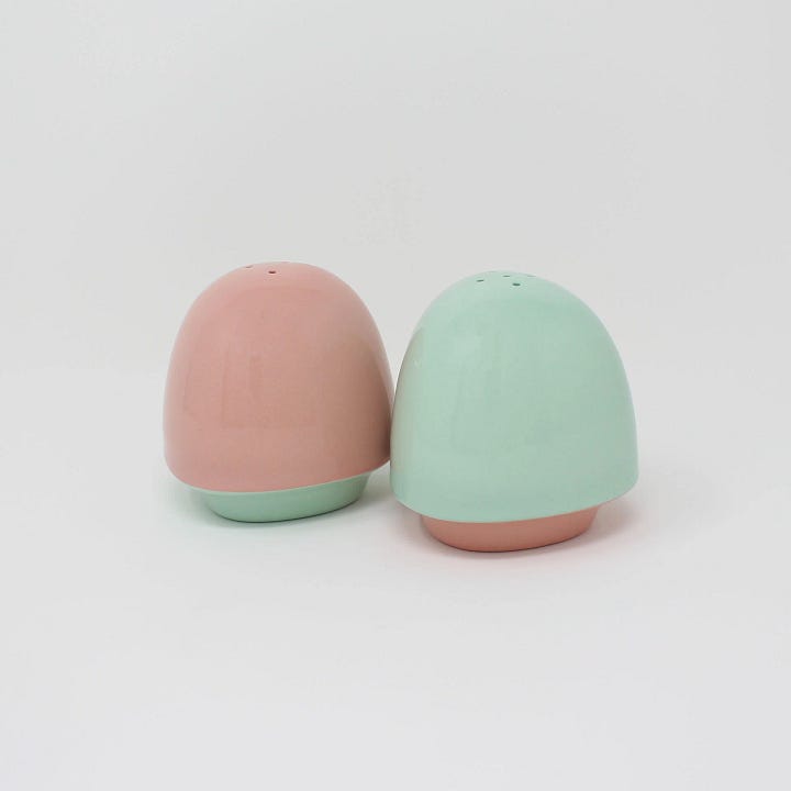 First Photo: a set of  handmade, rounded, teal and pink, ceramic salt and pepper shakers by E Lo Ceramic Arts.  Second photo: a gold plated four leaf clover pin by HEMLEVA