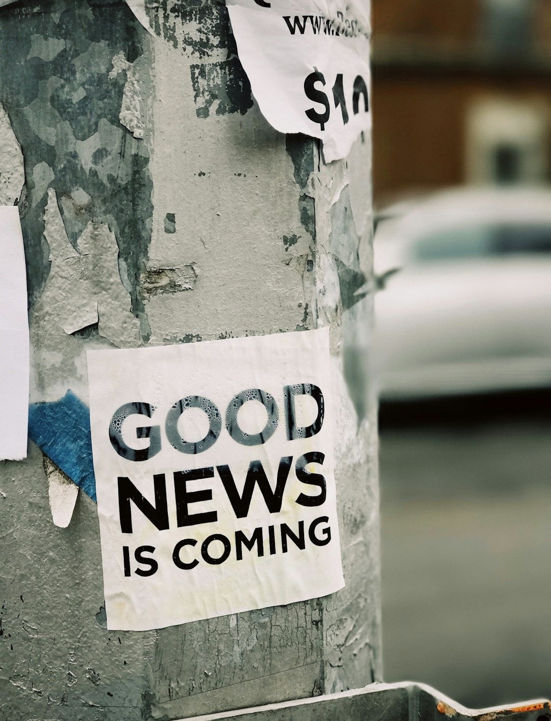 white Good News Is Coming paper on wall