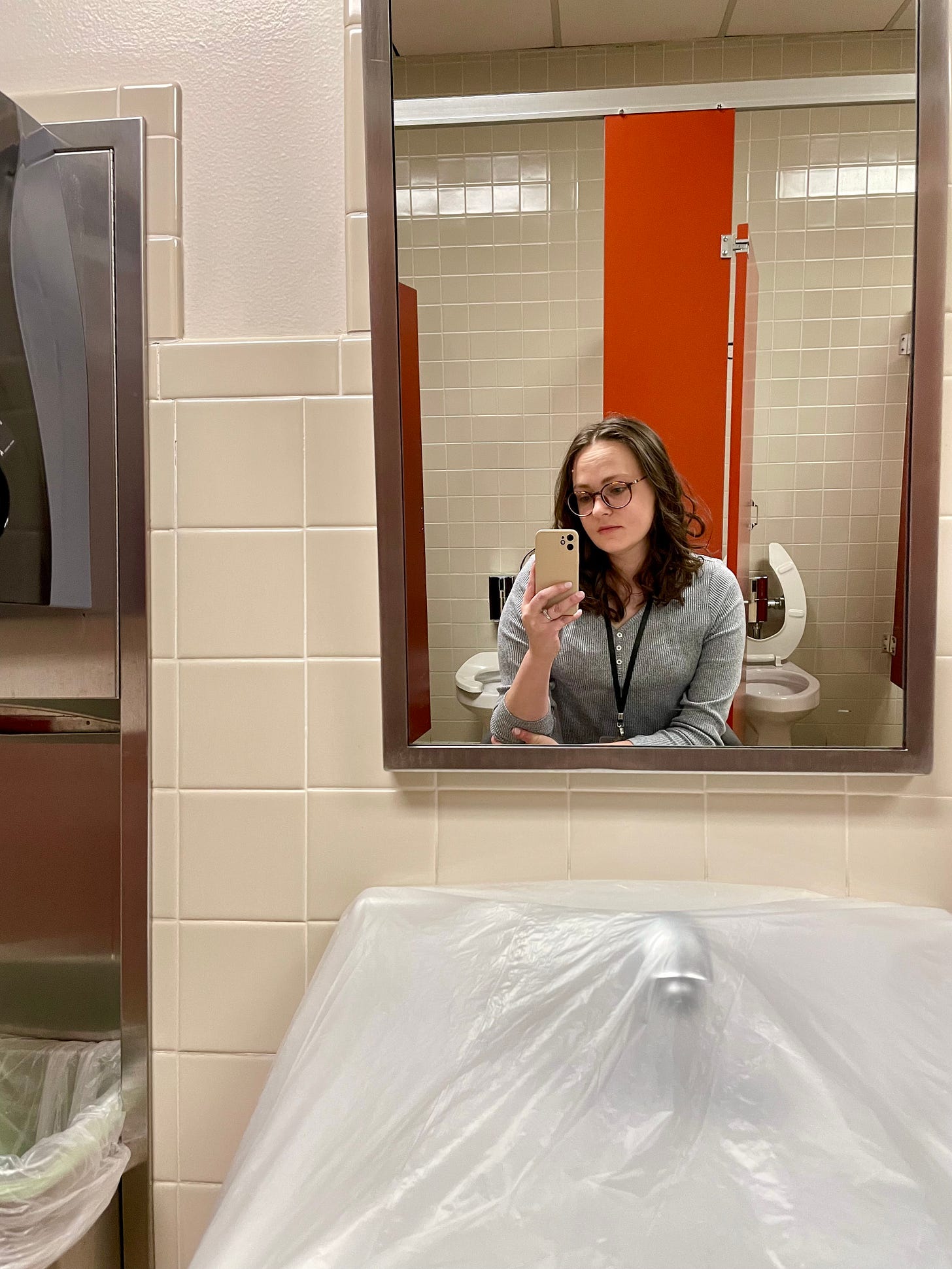 Jenna takes a bathroom mirror selfie. The sink is covered in plastic. Jenna takes a bathroom mirror selfie. The sink is covered in plastic.