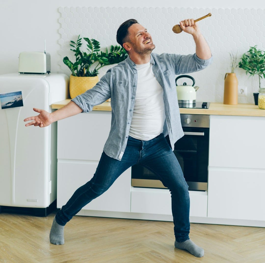 a man standing on a hard wood floor in a kitchen a man standing on a hard wood floor in a kitchen
