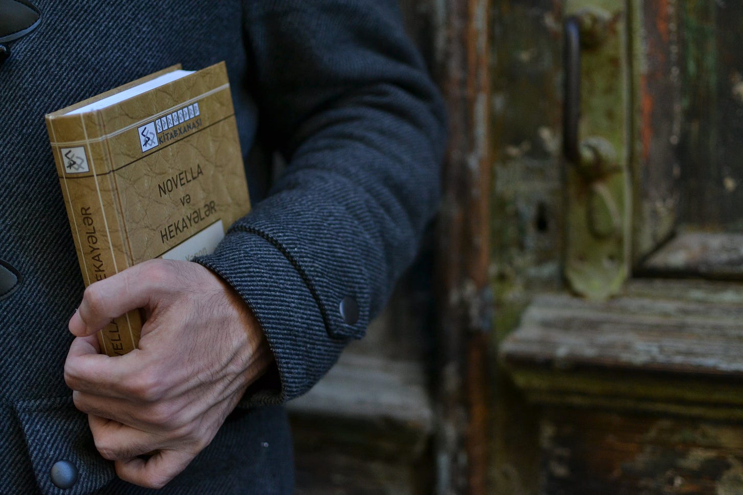 Free Person in Dark Gray Blazer Holding a Brown Book  Stock Photo