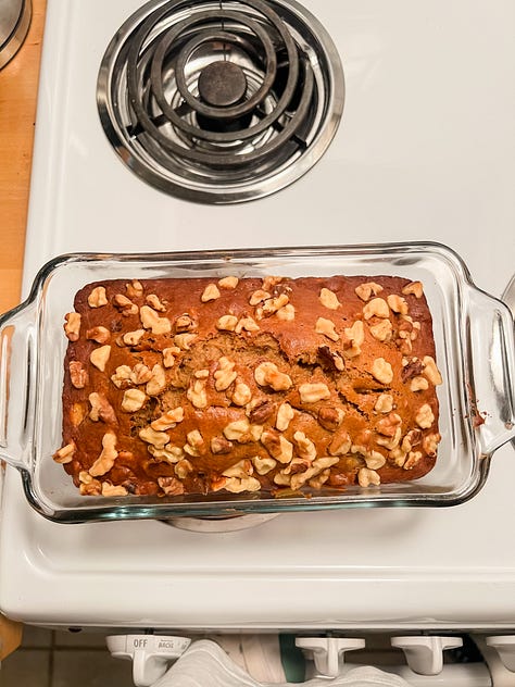 Photo of two women with a mountain landscape in the background; selfie photo of two women and a dog in a car; Selfie photo of woman with a dog sitting in a car; selfie photo of a family of four adults: brother and sister, and mom and dad; photo of two hands in shape of a heart in foreground and a mixing bowl with banana bread mix behind and below it; a baked banana bread in a glass loaf pan atop a stove; a photo of a carrot cake with glazed frosting and chopped pecans sprinkled on top; photo of a garden plot of blossoming flowers and vegetables and a placard in front that reads 'community garden'; photo of dog on couch curled up next to photographer's legs.