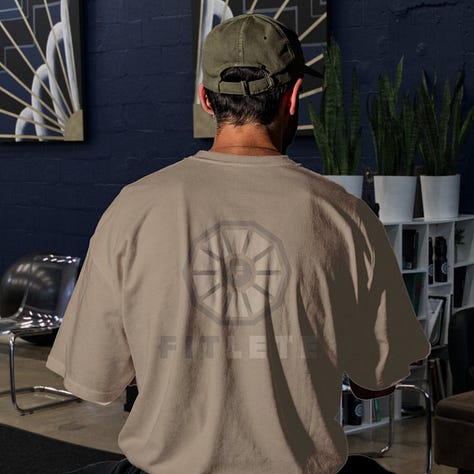 The toned fitlete logo sits on top of a shirt with its same color at a different shade or tone.