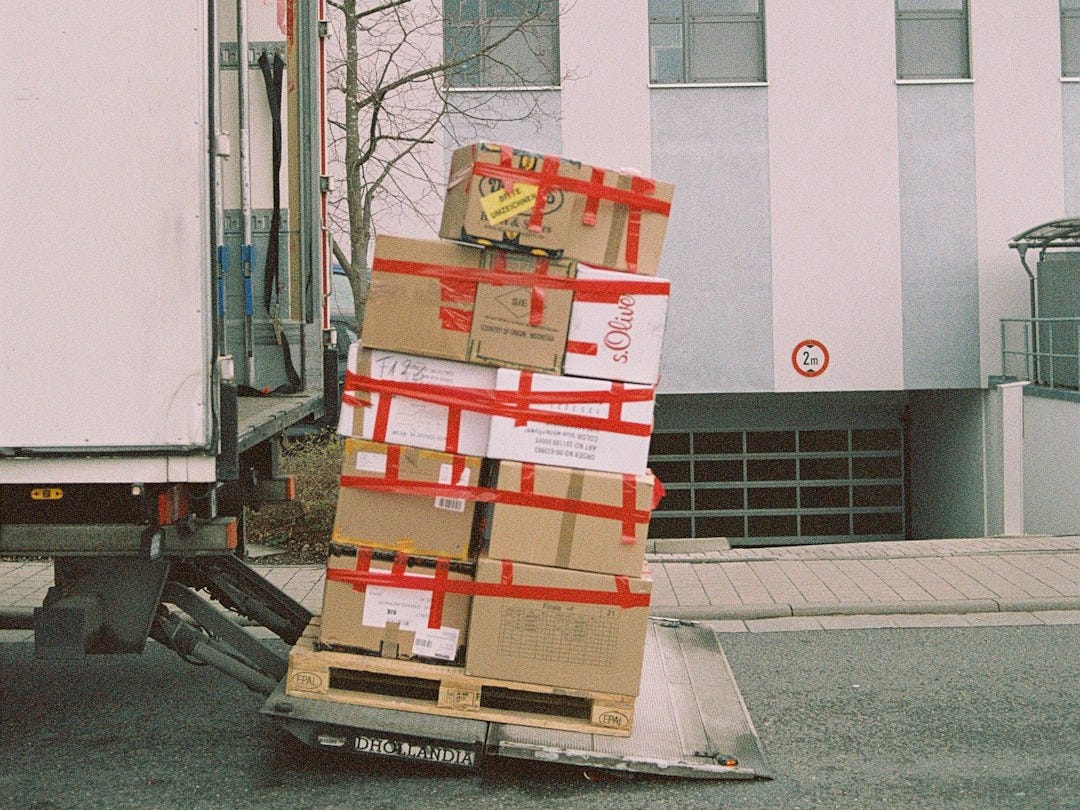 brown cardboard boxes on gray asphalt road brown cardboard boxes on gray asphalt road