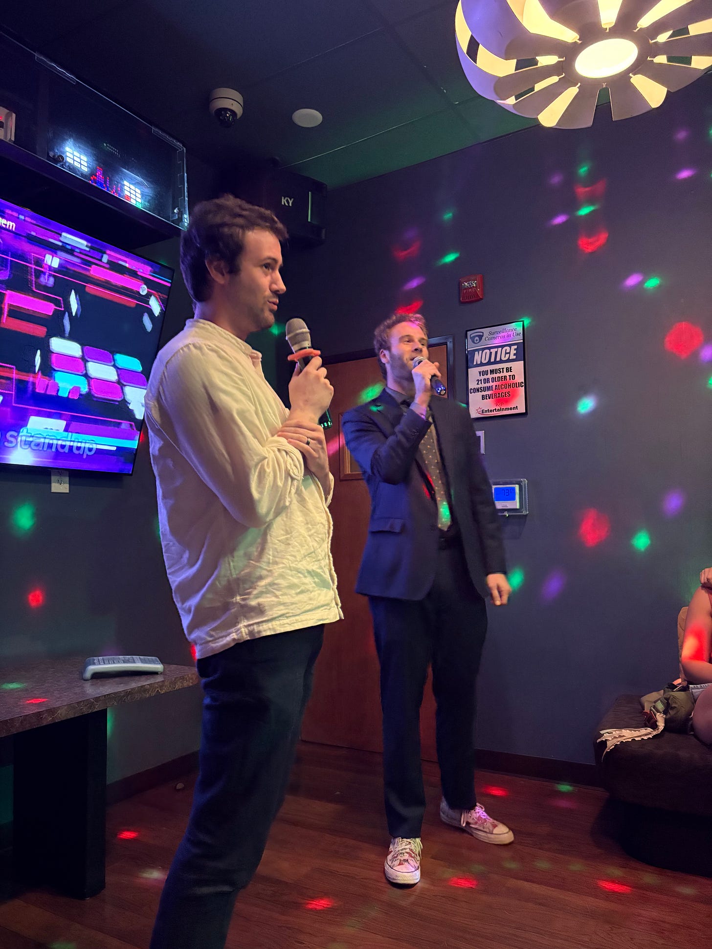Two young men sing karaoke together