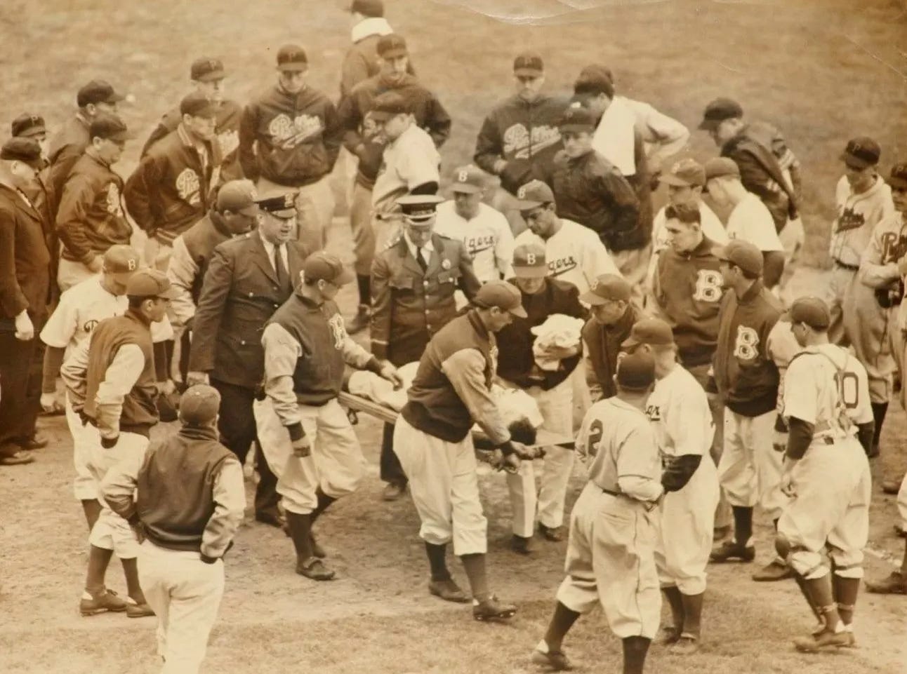 Pete Reiser is removed from the field on a stretcher as a crowd of players looks on. Pete Reiser is removed from the field on a stretcher as a crowd of players looks on.