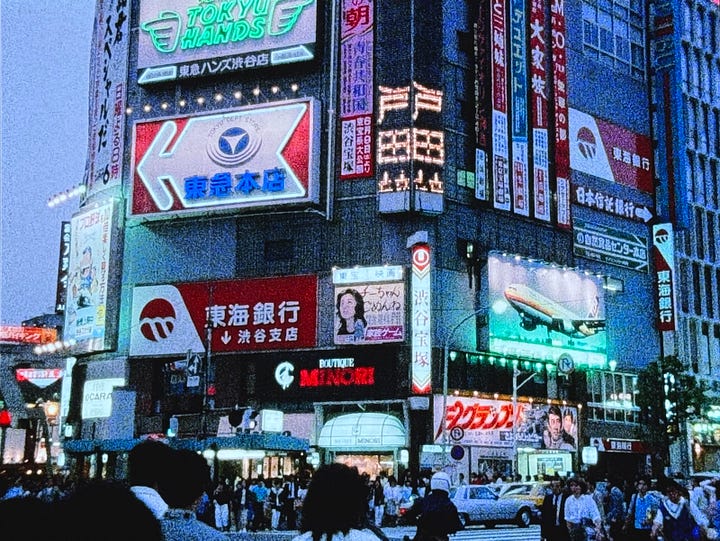 Still images from Tokyo Melody: Sakamoto playing piano, images of Tokyo subway system, street crossing, and utility workers.