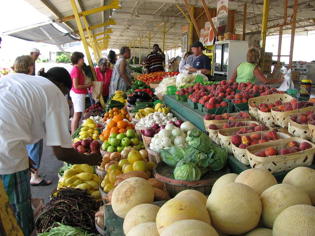 Photograph of people shopping for fresh fruit and produce at a farmer's market