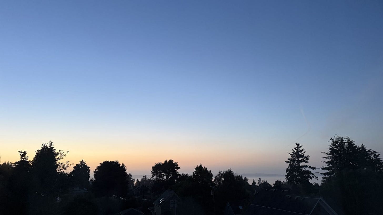 Dawn sky over Port Townsend viewed from the rear of the Adams Pragge House across Admiralty Inlet towards Whidbey Island, with distant mountains obscured by maritime haze.