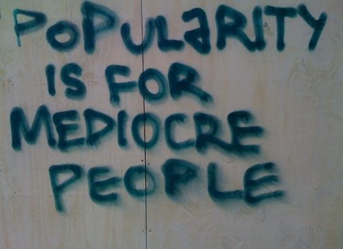 This may contain: graffiti written on the side of a wall that says, popularity is for mediocre people
