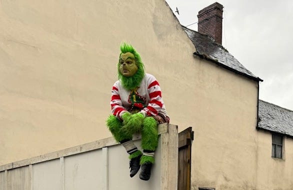 a grinch's fair sign with a grinch on top of it a grinch's fair sign with a grinch on top of it