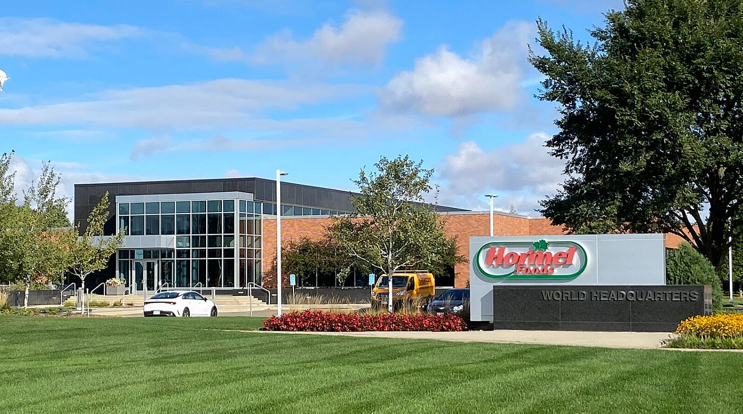 the Hormel Foods world headquarters sign next to a freshly mowed green lawn and building with glass windows the Hormel Foods world headquarters sign next to a freshly mowed green lawn and building with glass windows