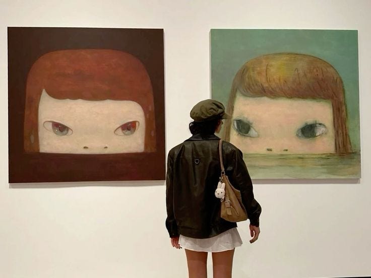 This may contain: a woman standing in front of two paintings